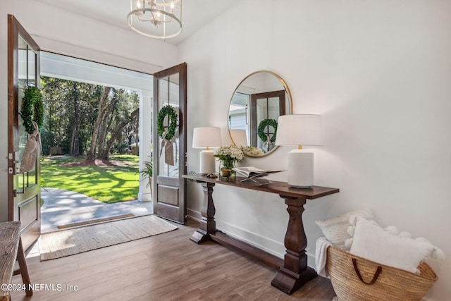 foyer entrance featuring hardwood / wood-style floors and an inviting chandelier