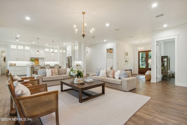 living room featuring a notable chandelier and light wood-type flooring