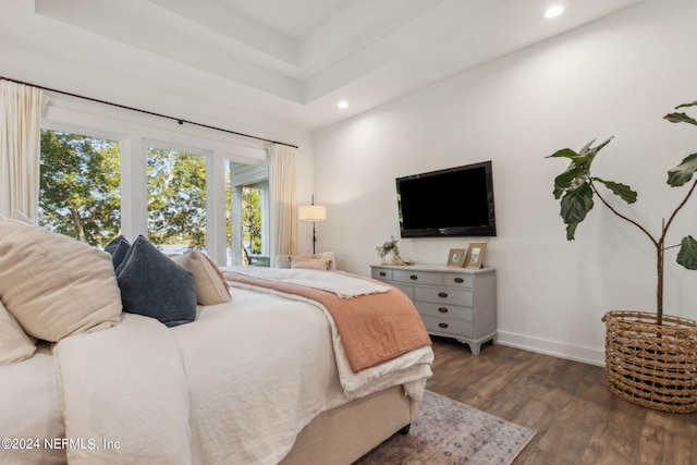 bedroom featuring dark hardwood / wood-style floors and a tray ceiling