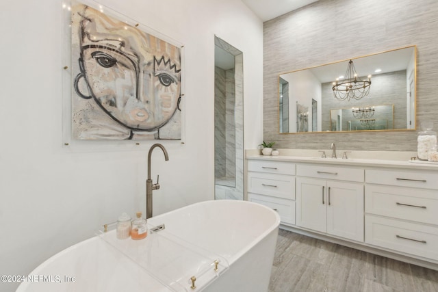 bathroom featuring vanity, a chandelier, a bathtub, and hardwood / wood-style flooring