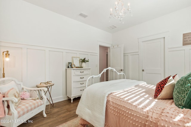 bedroom with a chandelier and dark hardwood / wood-style flooring