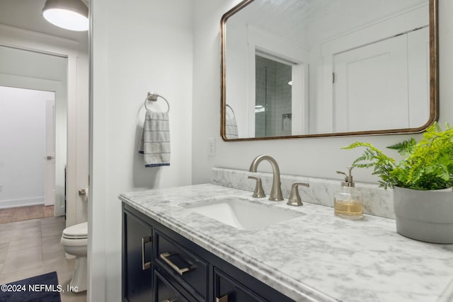 bathroom featuring walk in shower, vanity, toilet, and tile patterned floors