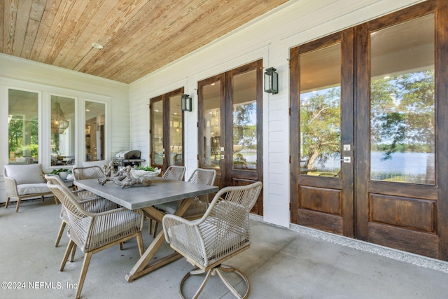 sunroom / solarium featuring french doors and wood ceiling