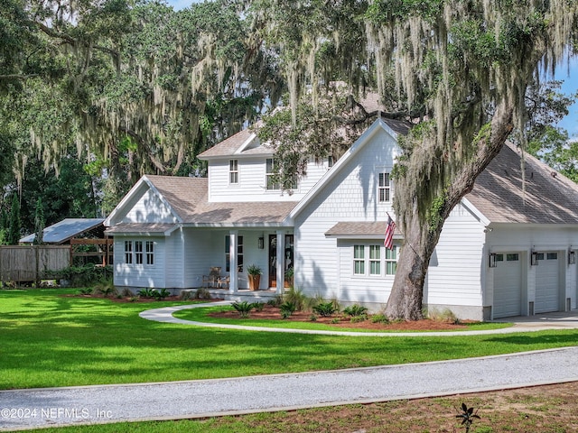 view of front facade with a front yard, a garage, and a porch