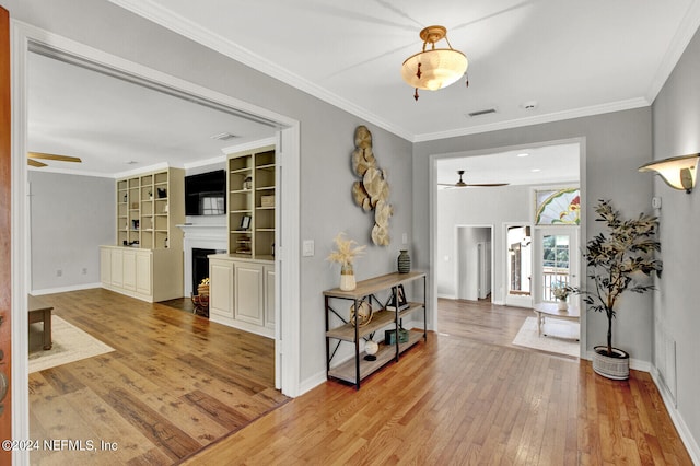 corridor with ornamental molding and hardwood / wood-style flooring