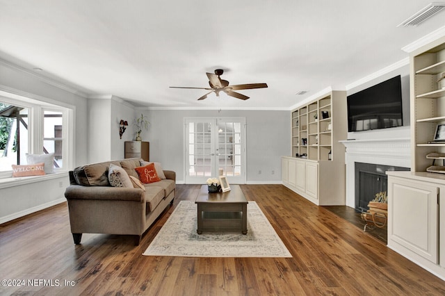 living room with dark wood-type flooring, crown molding, and ceiling fan