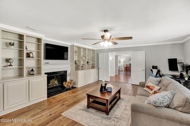 3565 Red Cloud Trl, Saint Augustine, FL 32086 - living room with a fireplace with flush hearth, crown molding, light wood-type flooring, and a ceiling fan