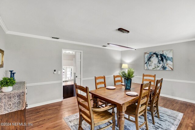 3565 Red Cloud Trl, Saint Augustine, FL 32086 - dining area with wood finished floors, visible vents, baseboards, and ornamental molding