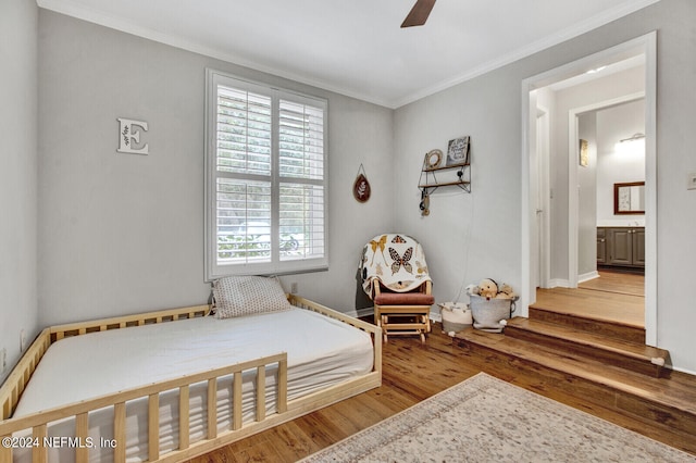 bedroom with ornamental molding, hardwood / wood-style floors, ensuite bath, and ceiling fan