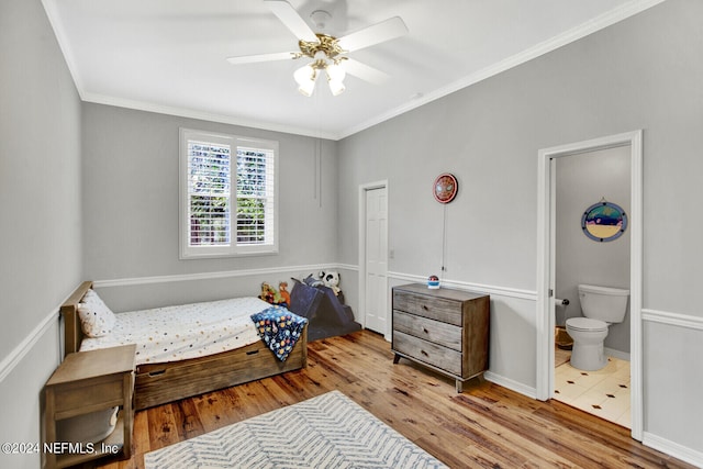 bedroom featuring ornamental molding, hardwood / wood-style floors, ensuite bath, and ceiling fan