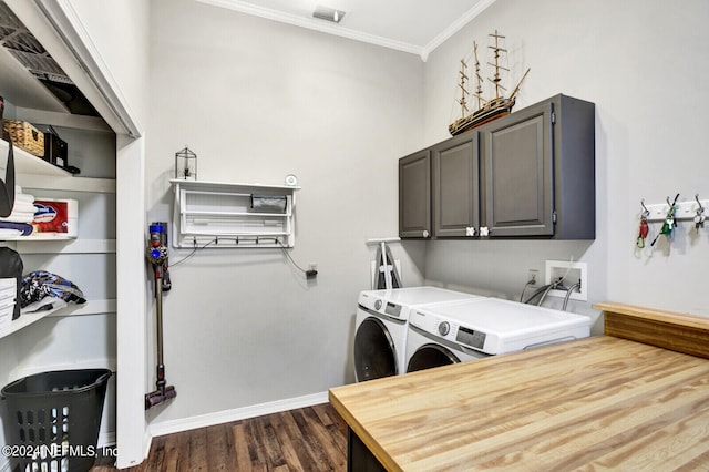 washroom featuring ornamental molding, washing machine and dryer, cabinets, and dark hardwood / wood-style flooring