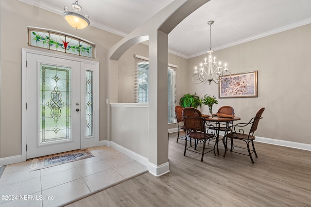 entryway featuring light hardwood / wood-style floors, a notable chandelier, and ornamental molding