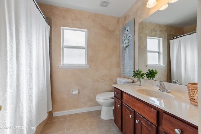 bathroom with toilet, vanity, tile patterned floors, and plenty of natural light