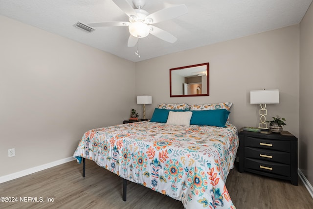 bedroom featuring a textured ceiling, dark hardwood / wood-style floors, and ceiling fan