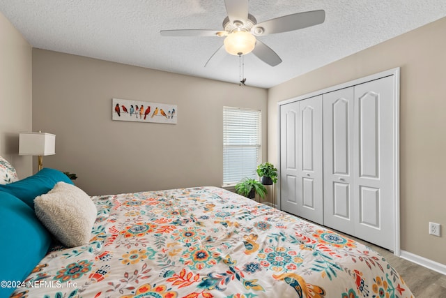 bedroom with a closet, a textured ceiling, hardwood / wood-style flooring, and ceiling fan