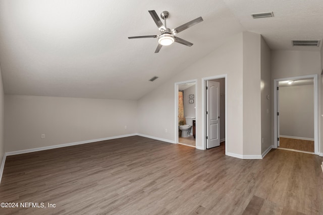 additional living space with a textured ceiling, ceiling fan, wood-type flooring, and vaulted ceiling