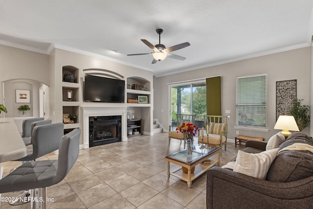 tiled living room featuring crown molding, a textured ceiling, built in features, and ceiling fan