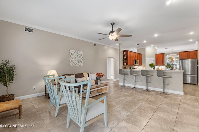 tiled dining area featuring crown molding and ceiling fan