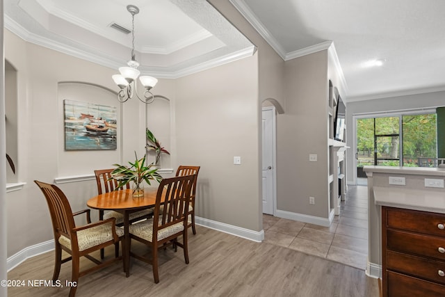 dining area featuring crown molding, light hardwood / wood-style flooring, and an inviting chandelier