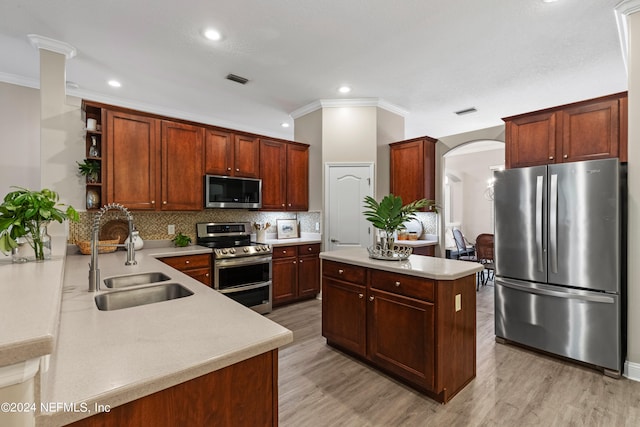 kitchen with stainless steel appliances, ornamental molding, sink, light wood-type flooring, and tasteful backsplash