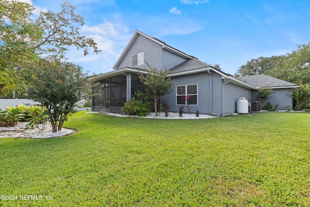 back of house with cooling unit, a lawn, and a sunroom