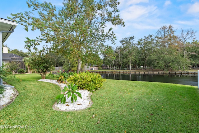 view of yard with a water view and a lanai