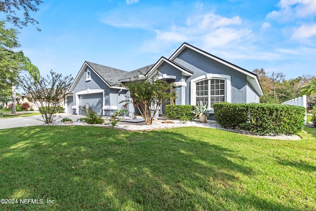 view of front of home with a front yard and a garage