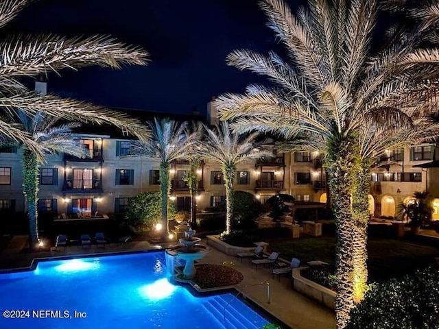 view of pool at twilight