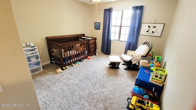 carpeted bedroom featuring a crib