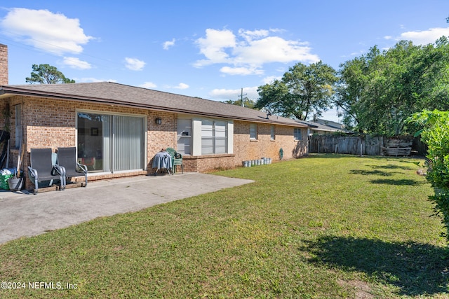 rear view of house featuring a patio and a lawn