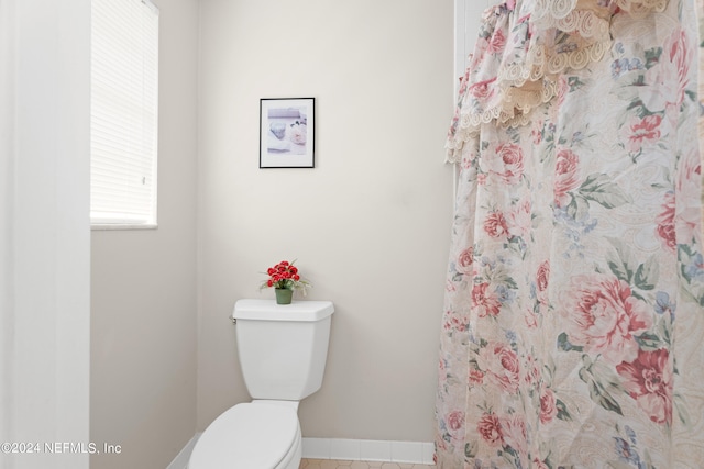 bathroom with toilet and a shower with curtain