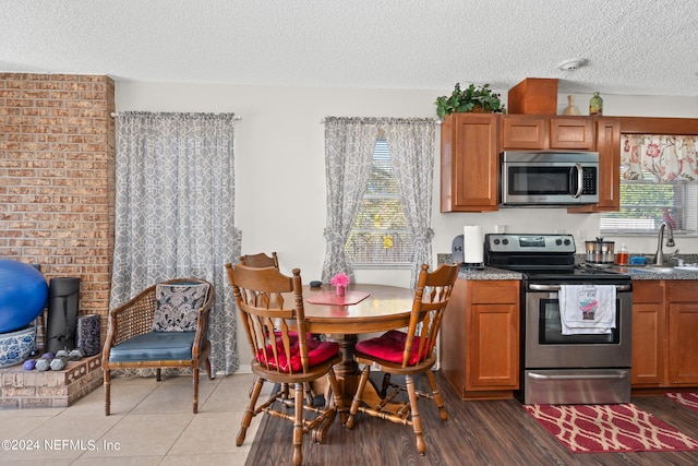 kitchen featuring sink, hardwood / wood-style floors, stainless steel appliances, and a textured ceiling