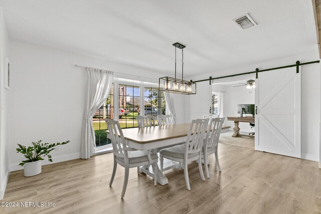 dining area featuring light hardwood / wood-style floors and a barn door