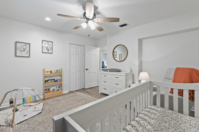 bedroom featuring a closet, light hardwood / wood-style floors, and ceiling fan