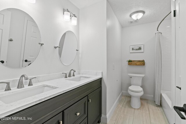 full bathroom featuring tile patterned flooring, a textured ceiling, shower / tub combo, vanity, and toilet