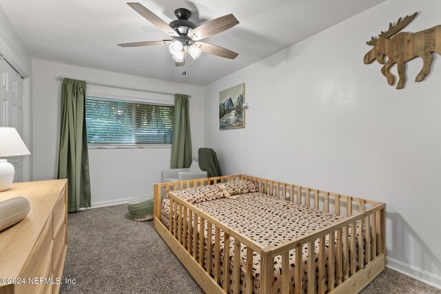 carpeted bedroom with ceiling fan and a closet