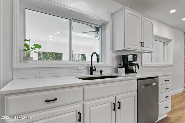 kitchen with light hardwood / wood-style floors, a wealth of natural light, sink, and white cabinetry