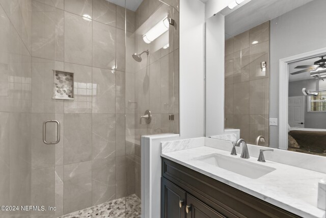 bathroom with walk in shower, vanity, and ceiling fan