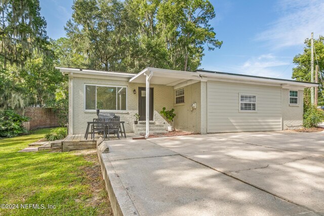 view of front of house featuring a patio and a front lawn