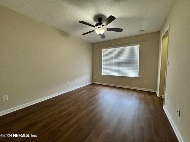 unfurnished room with a textured ceiling, dark hardwood / wood-style floors, and ceiling fan