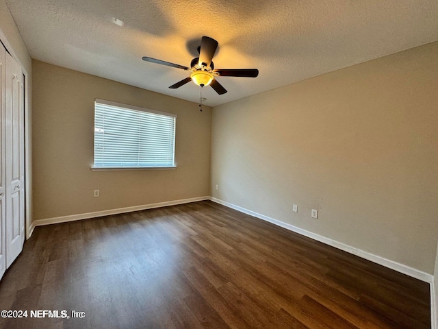 interior space featuring a textured ceiling, dark wood-type flooring, ceiling fan, and a closet