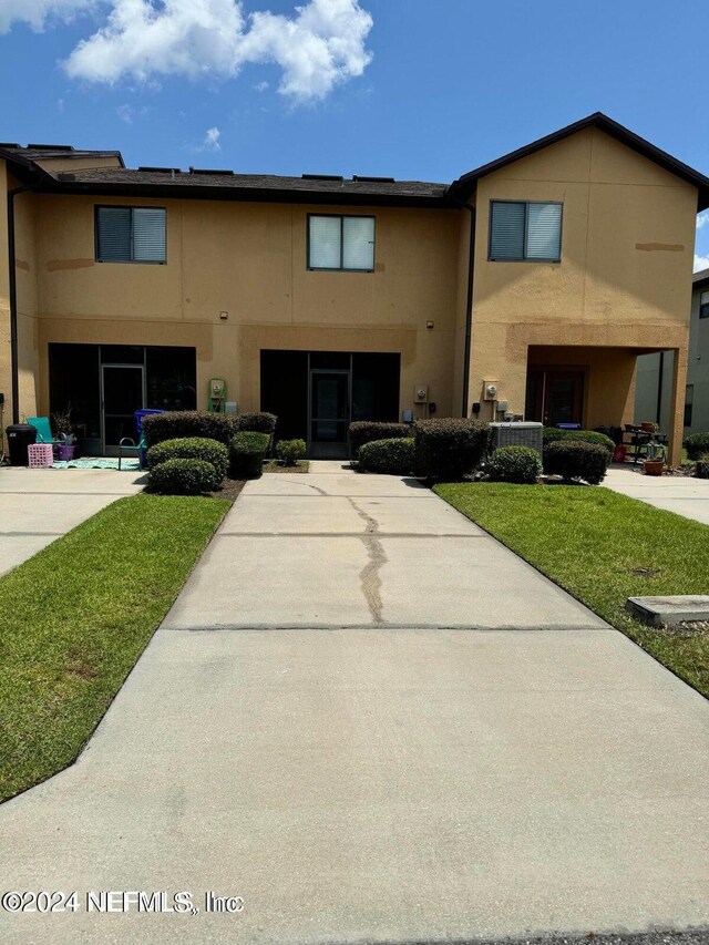 view of front of home featuring a front lawn and central air condition unit