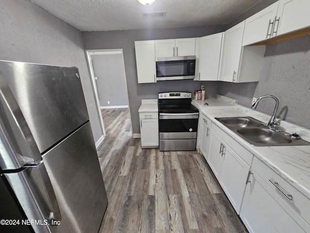 kitchen featuring sink, a textured ceiling, white cabinets, and stainless steel appliances