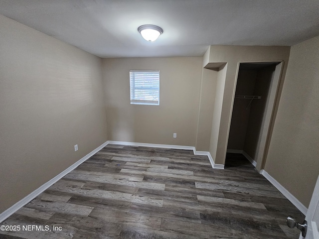 unfurnished bedroom with a closet and dark hardwood / wood-style flooring