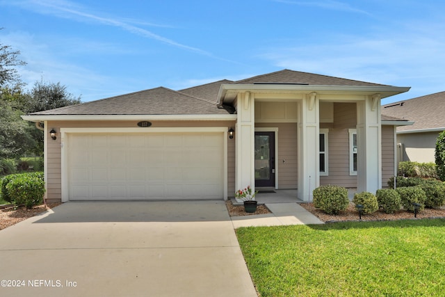 prairie-style home featuring a garage and a front lawn