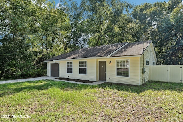 single story home featuring a garage and a front lawn