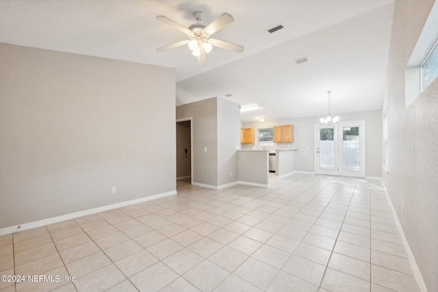 unfurnished living room featuring ceiling fan with notable chandelier, light tile patterned floors, and plenty of natural light