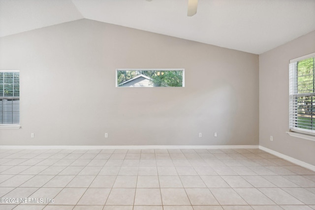 tiled spare room featuring vaulted ceiling and ceiling fan