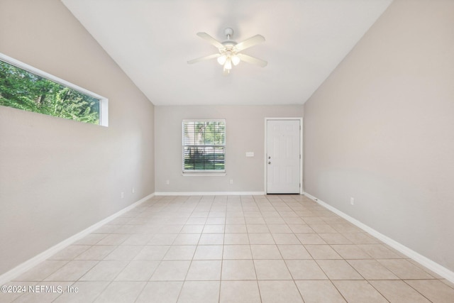 spare room featuring lofted ceiling, light tile patterned flooring, and ceiling fan