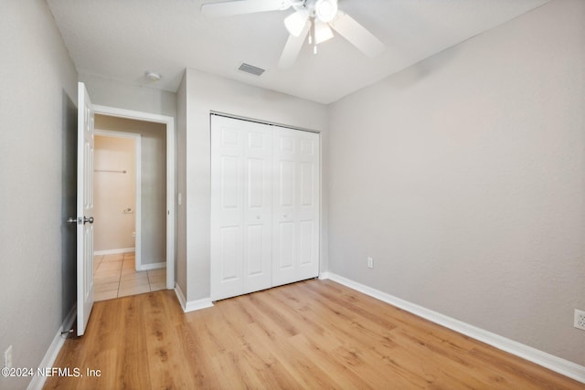 unfurnished bedroom featuring a closet, light wood-type flooring, and ceiling fan